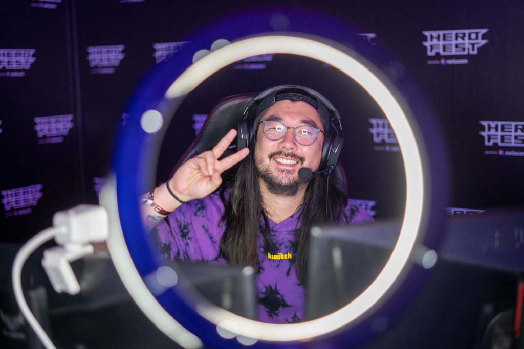 Twitch-Streamer am Herofest macht das Peace-Zeichen in die Kamera.